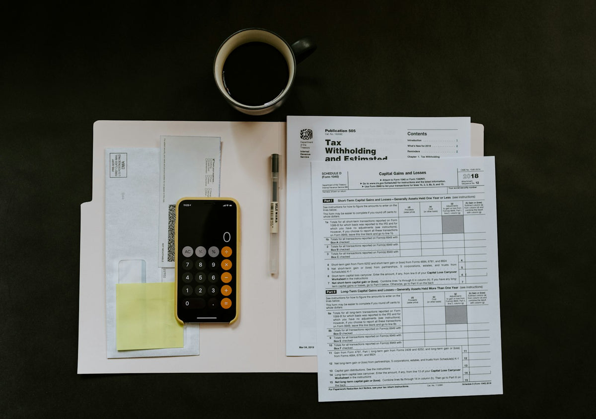 Tax withholding form beside a smartphone and pen