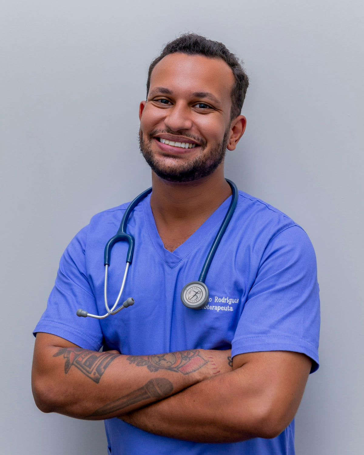 Smiling healthcare worker in blue scrubs with a stethoscope