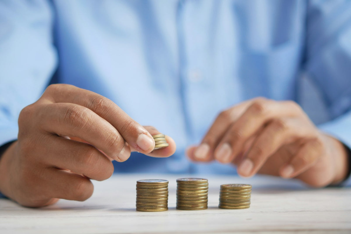 Person stacking coins on a table