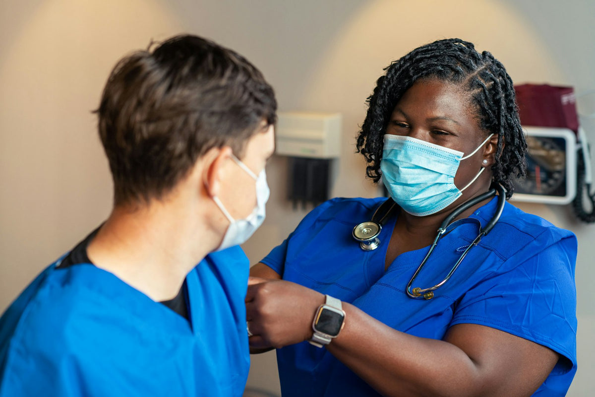 Two healthcare workers in blue scrubs